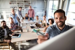 Das Bild zeigt eine Gruppe, die gemeinsam etwas an einer Flipchart erarbeitet. ©iStock / skynesher