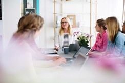 Das Bild zeigt mehrere Personen mit Laptops bei einer Gruppenbesprechung. ©iStock / alvarez